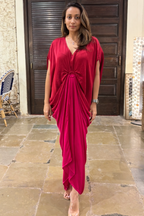 Woman in a red dress standing on a stone pavement with a building in the background