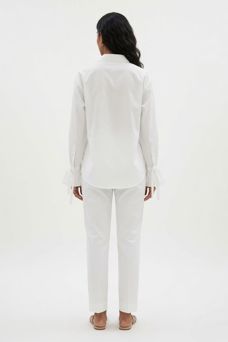 Woman wearing a white sleeveless jumpsuit on a white background